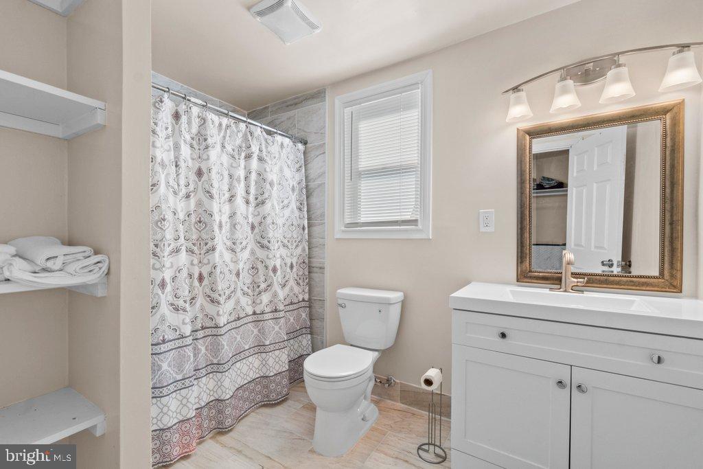 4919 Harford Road Baltimore, MD 21214 - Photo 34 of 48 a bathroom with a toilet sink and mirror