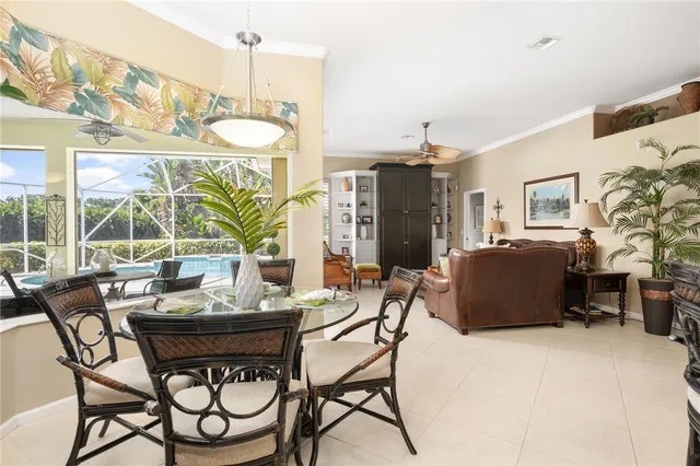 a living room with furniture a chandelier and a dining table