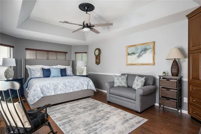 a bedroom with a bed couches and wooden floor