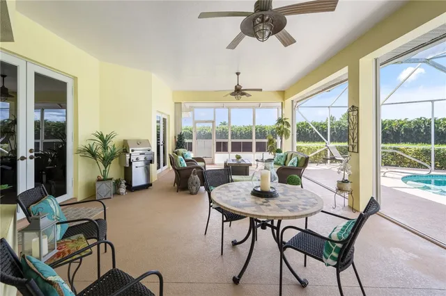 a dining room with furniture a chandelier and glass door