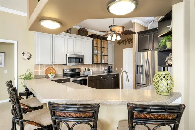 a kitchen with stainless steel appliances granite countertop a stove refrigerator a microwave oven with a dining table and chairs