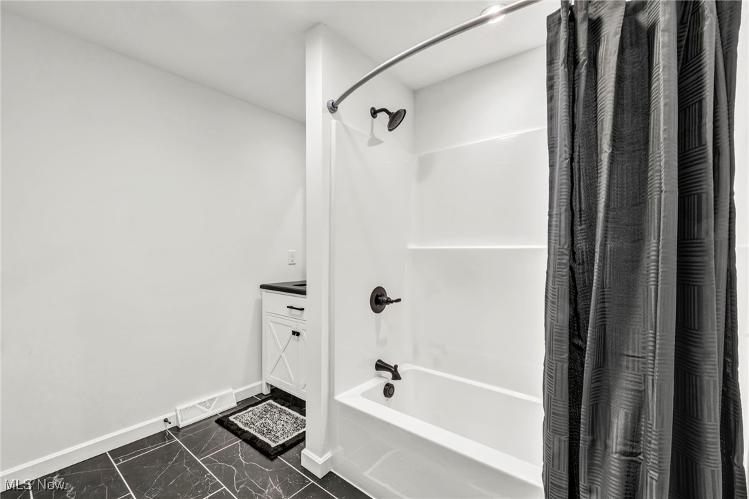 43575 Cream Ridge Road Lisbon, OH 44432 - Photo 25 of 50 Bathroom featuring shower / bathtub combination with curtain, dark marble finish floors, and vanity