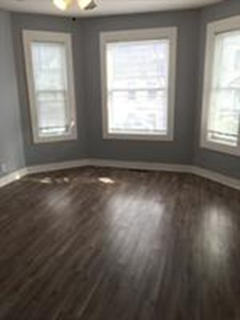 1 Proctor Street Haverhill, MA 01832 - Photo 2 of 6 a view of an empty room with wooden floor and a window