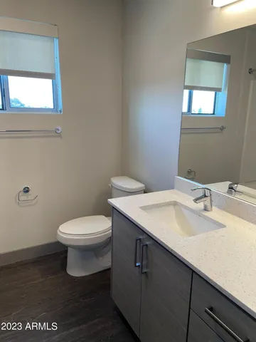 a bathroom with a sink a toilet and mirror