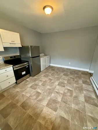an empty room with wooden floor and mirror