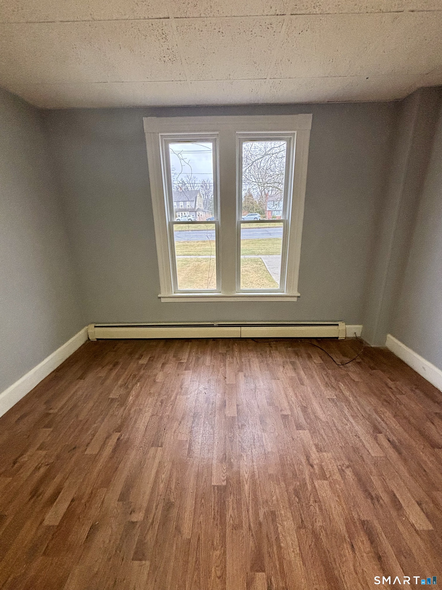 411 Main Street, Unit 1 Cromwell, CT 06416 - Photo 8 of 15 an empty room with wooden floor and windows