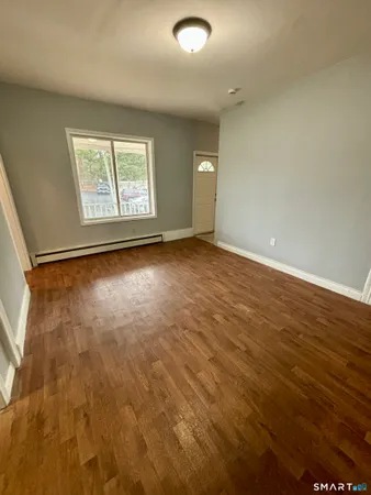 a view of room with window and wooden floor