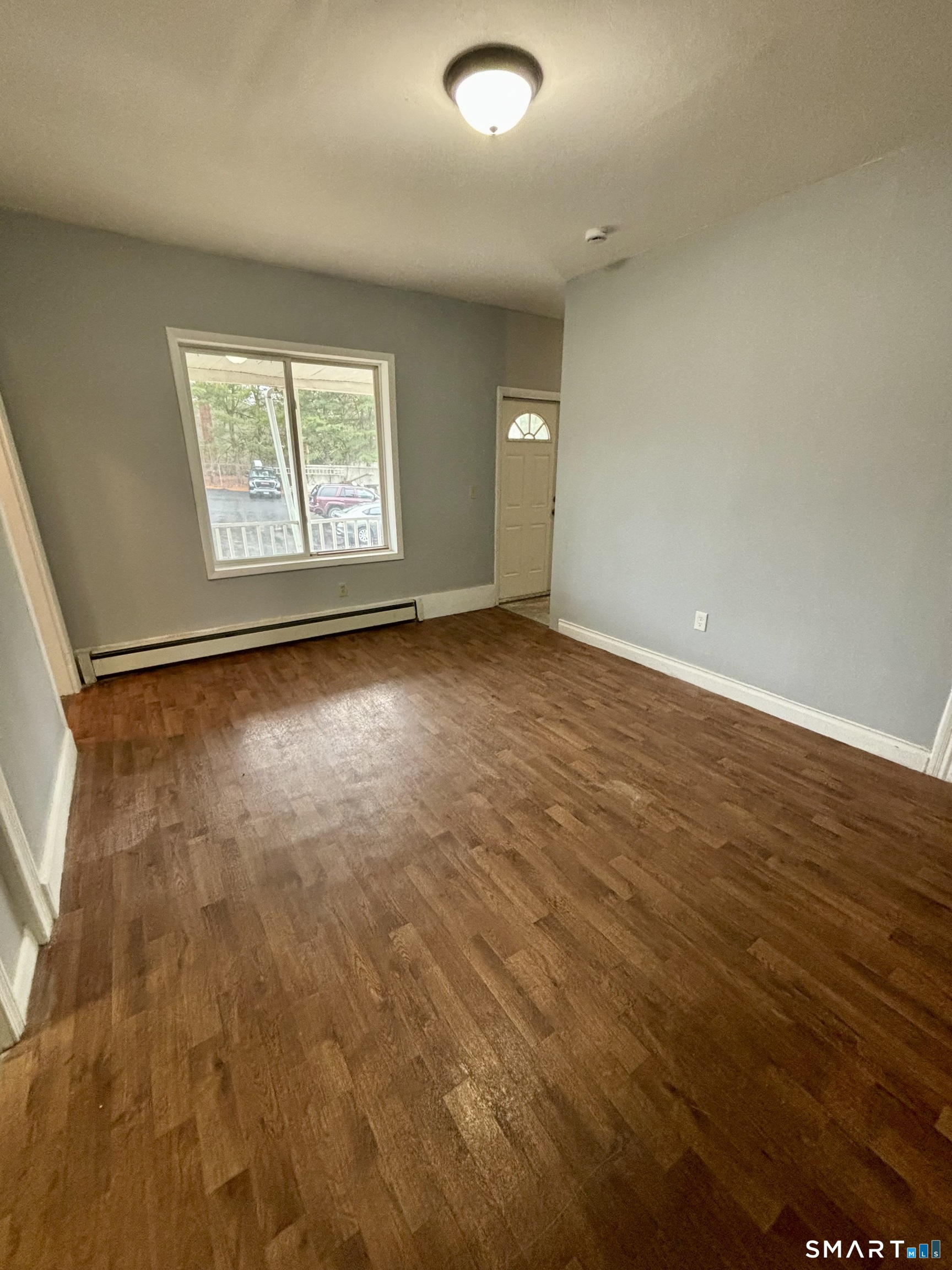 411 Main Street, Unit 1 Cromwell, CT 06416 - Photo 9 of 15 an empty room with wooden floor and windows