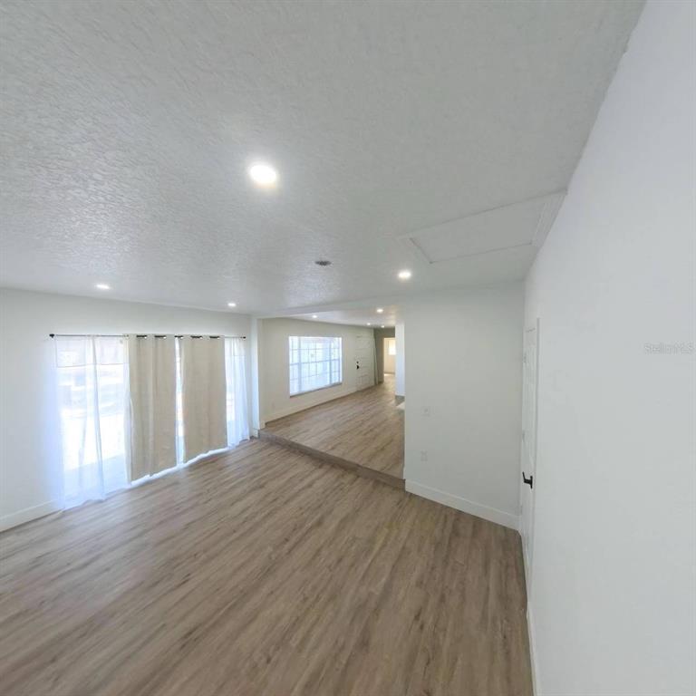 905 Spring Creek Drive Ocoee, FL 34761 - Photo 11 of 43 wooden floor in an empty room with a window