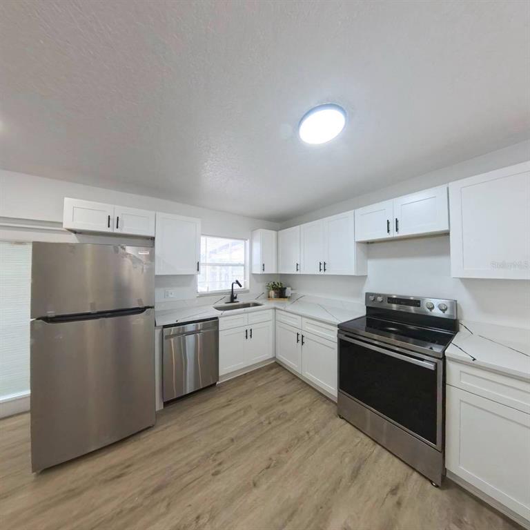 905 Spring Creek Drive Ocoee, FL 34761 - Photo 13 of 43 a kitchen with a refrigerator and a stove top oven