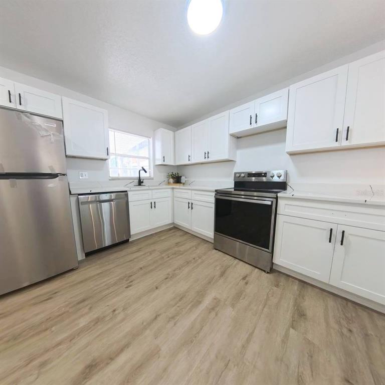 905 Spring Creek Drive Ocoee, FL 34761 - Photo 16 of 43 a kitchen with granite countertop a refrigerator stove top oven and sink