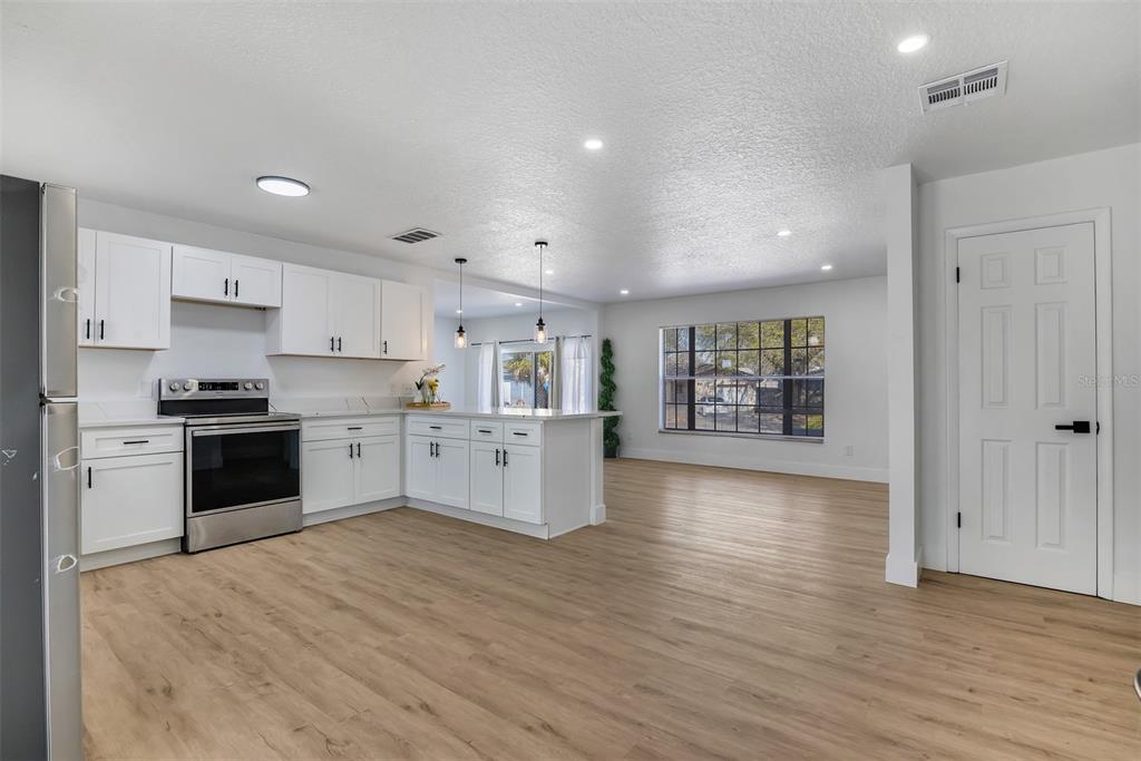 905 Spring Creek Drive Ocoee, FL 34761 - Photo 18 of 35 a large kitchen with a wooden floor and a stove top oven