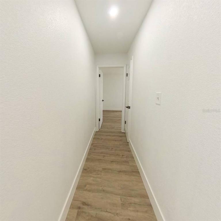 905 Spring Creek Drive Ocoee, FL 34761 - Photo 24 of 43 a view of a hallway with wooden floor