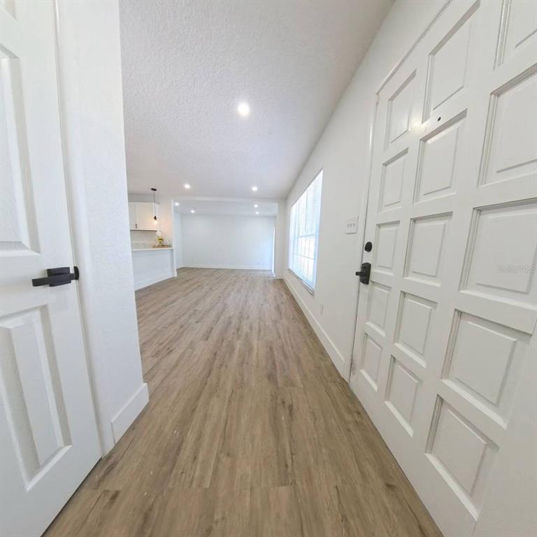 905 Spring Creek Drive Ocoee, FL 34761 - Photo 9 of 43 a view of a hallway with wooden floor