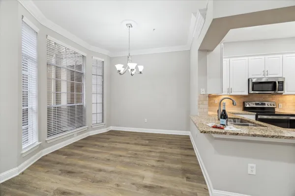 a view of a kitchen with granite countertop stainless steel appliances and a sink