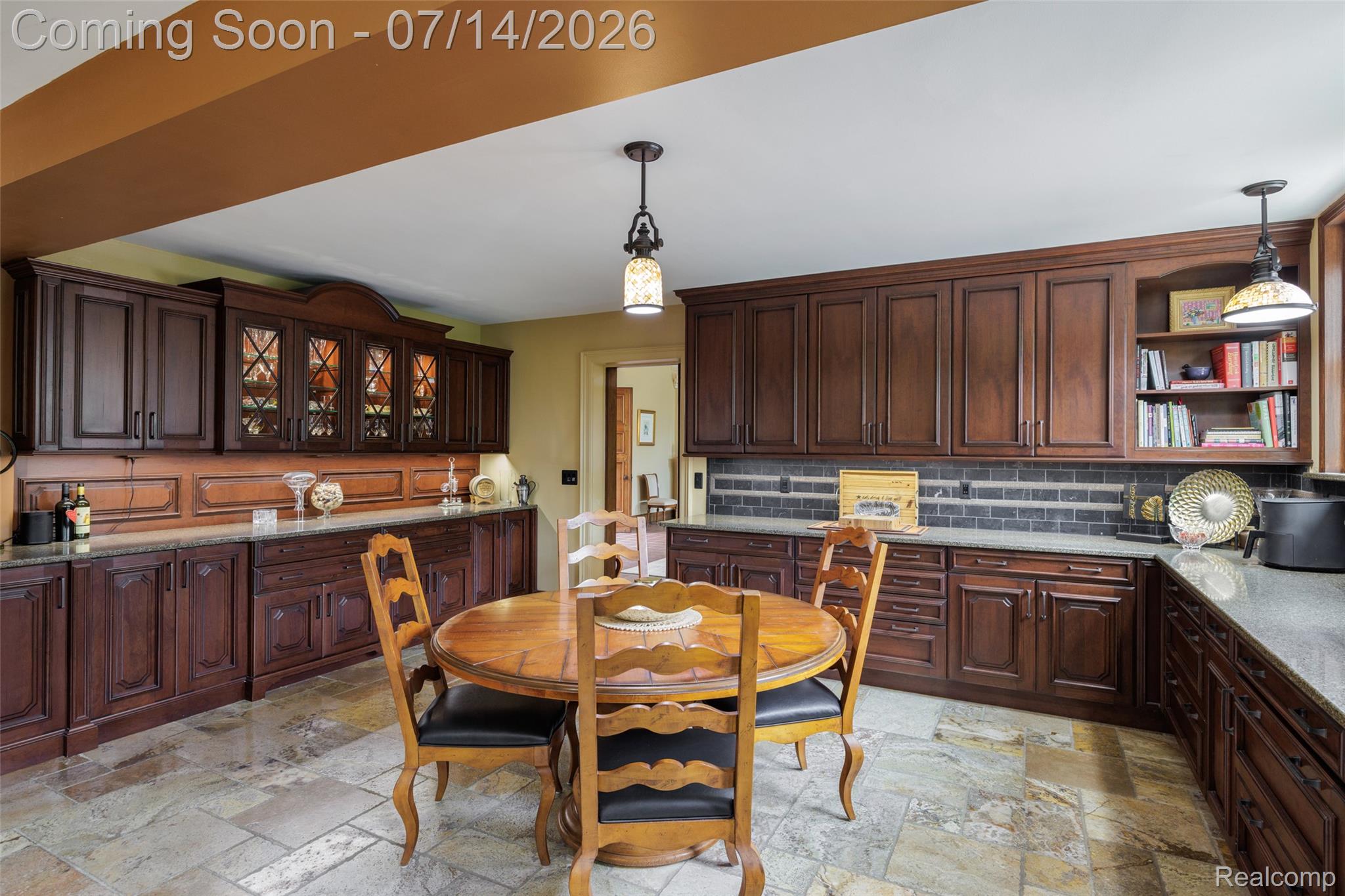 189 Cloverly Road Grosse Pointe, MI 48236 - Photo 25 of 96 Kitchen featuring extensive dark wood cabinetry, light-toned stone-finish flooring, and pendant lighting