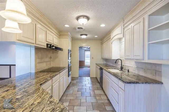 a large kitchen with stainless steel appliances granite countertop a sink and a stove