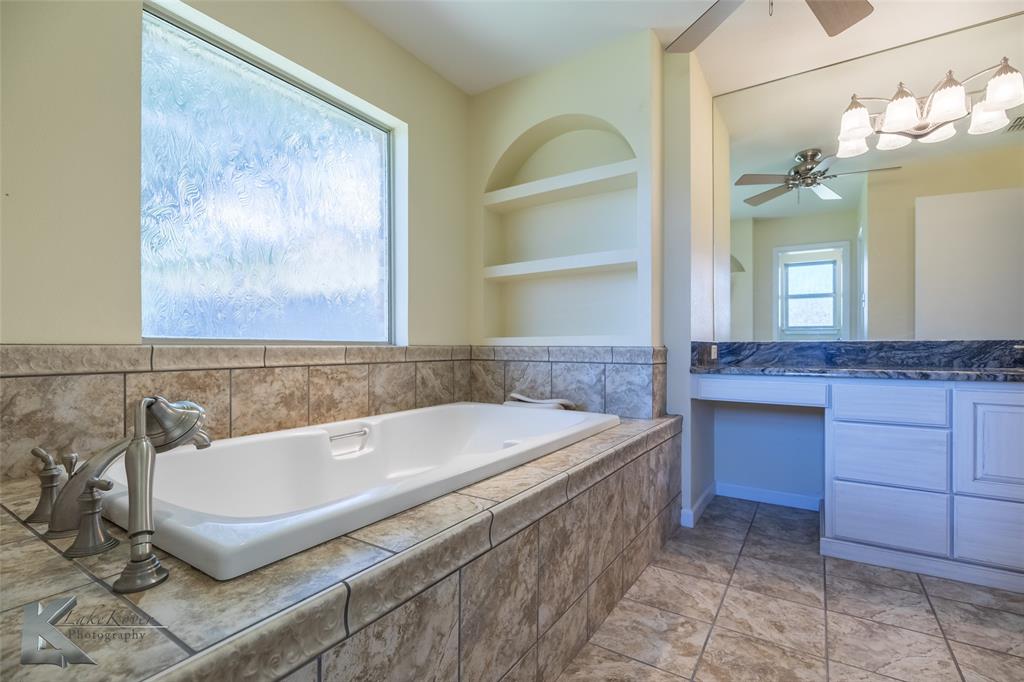 220 Hedges Road Abilene, TX 79605 - Photo 21 of 40 a bathroom with a tub sink and mirror