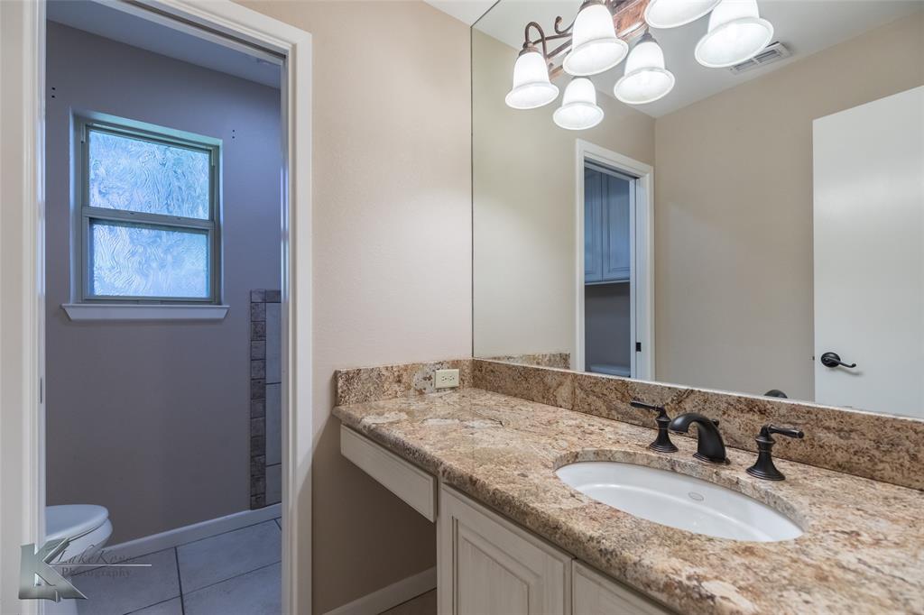 220 Hedges Road Abilene, TX 79605 - Photo 25 of 40 a bathroom with a granite countertop sink and a mirror