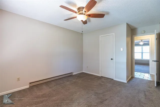 an empty room with closet and fan