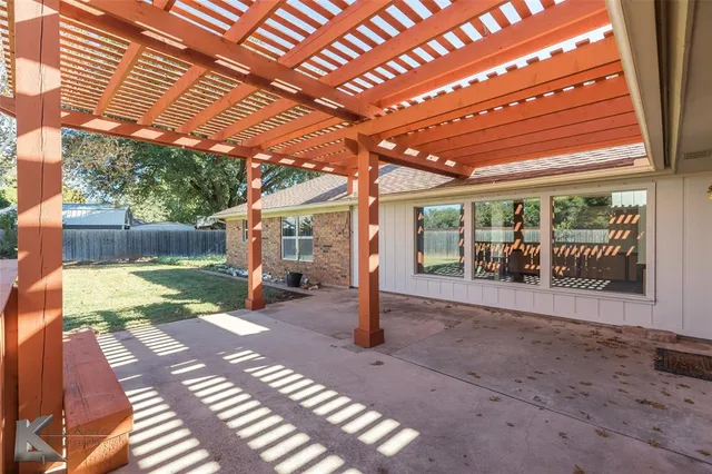 a view of a patio with table and chairs next to a yard