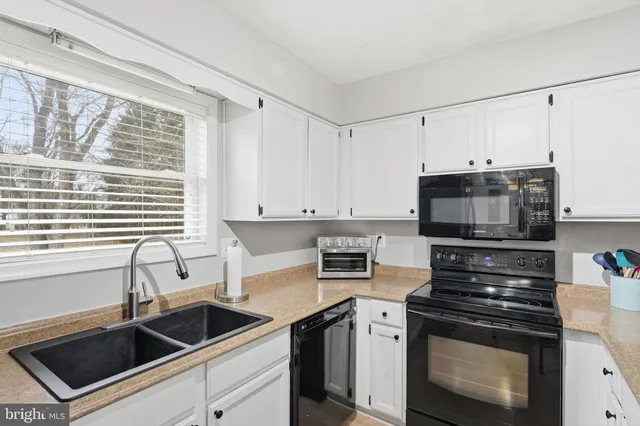 a kitchen with granite countertop a sink stove and microwave