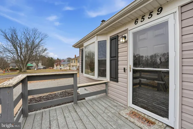 a view of a balcony with wooden floor and fence