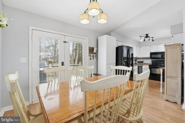 a view of a dining room with furniture a chandelier and wooden floor
