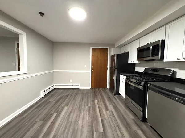 a kitchen with granite countertop stainless steel appliances and wooden floor