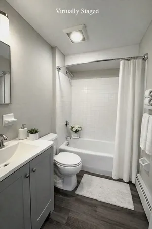 a bathroom with a double vanity sink toilet mirror and bathtub