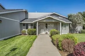 a view of a house with brick walls and a yard with plants
