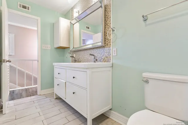 a bathroom with a toilet sink and mirror