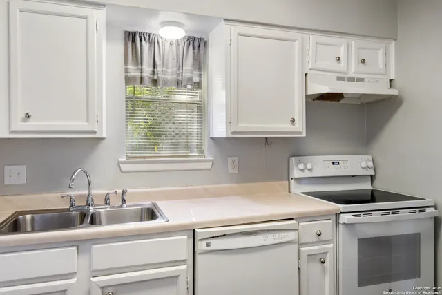 a kitchen with appliances cabinets and a sink