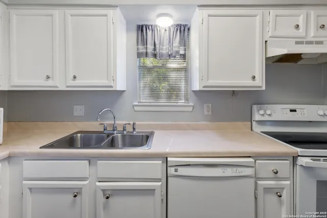 a kitchen with white cabinets and a sink