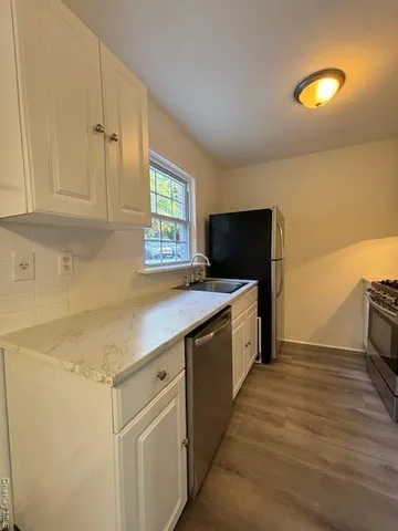a kitchen with stainless steel appliances a stove a sink and a microwave