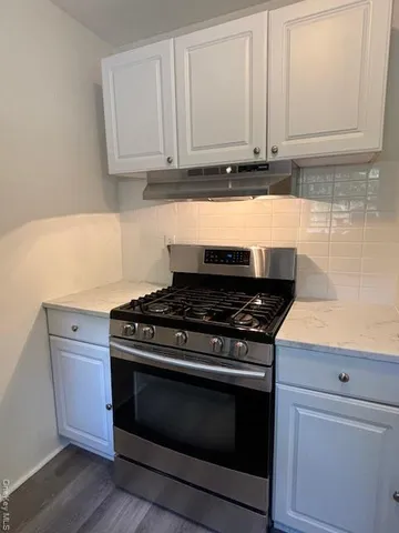 a stove top oven sitting inside of a kitchen