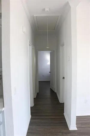 a view of a hallway with wooden floor
