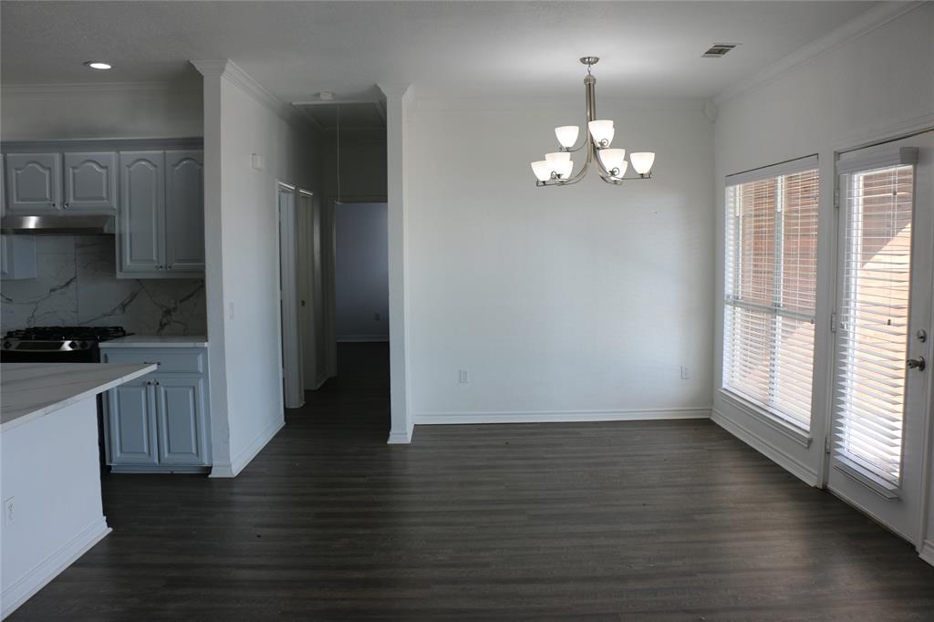 2858 Waters Edge Quinlan, TX 75474 - Photo 25 of 34 a view of an empty room with wooden floor and a kitchen