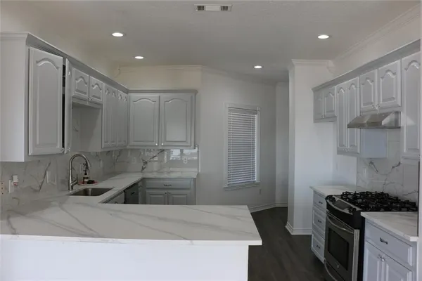 a kitchen with kitchen island a sink stove and refrigerator