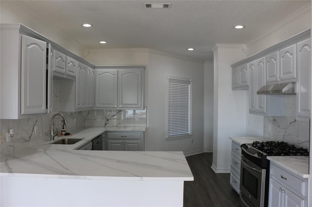 2858 Waters Edge Quinlan, TX 75474 - Photo 8 of 34 a kitchen with kitchen island a sink stove and refrigerator