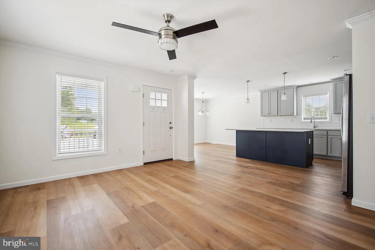 10 Ginger Lane Conowingo, MD 21918 - Photo 11 of 34 a view of kitchen and empty room with wooden floor and windows