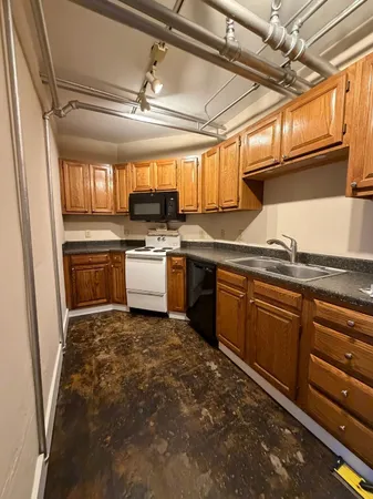 a kitchen with granite countertop a sink cabinets stainless steel appliances and a window