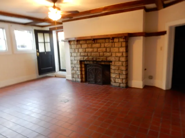 wooden floor fireplace and windows in an empty room