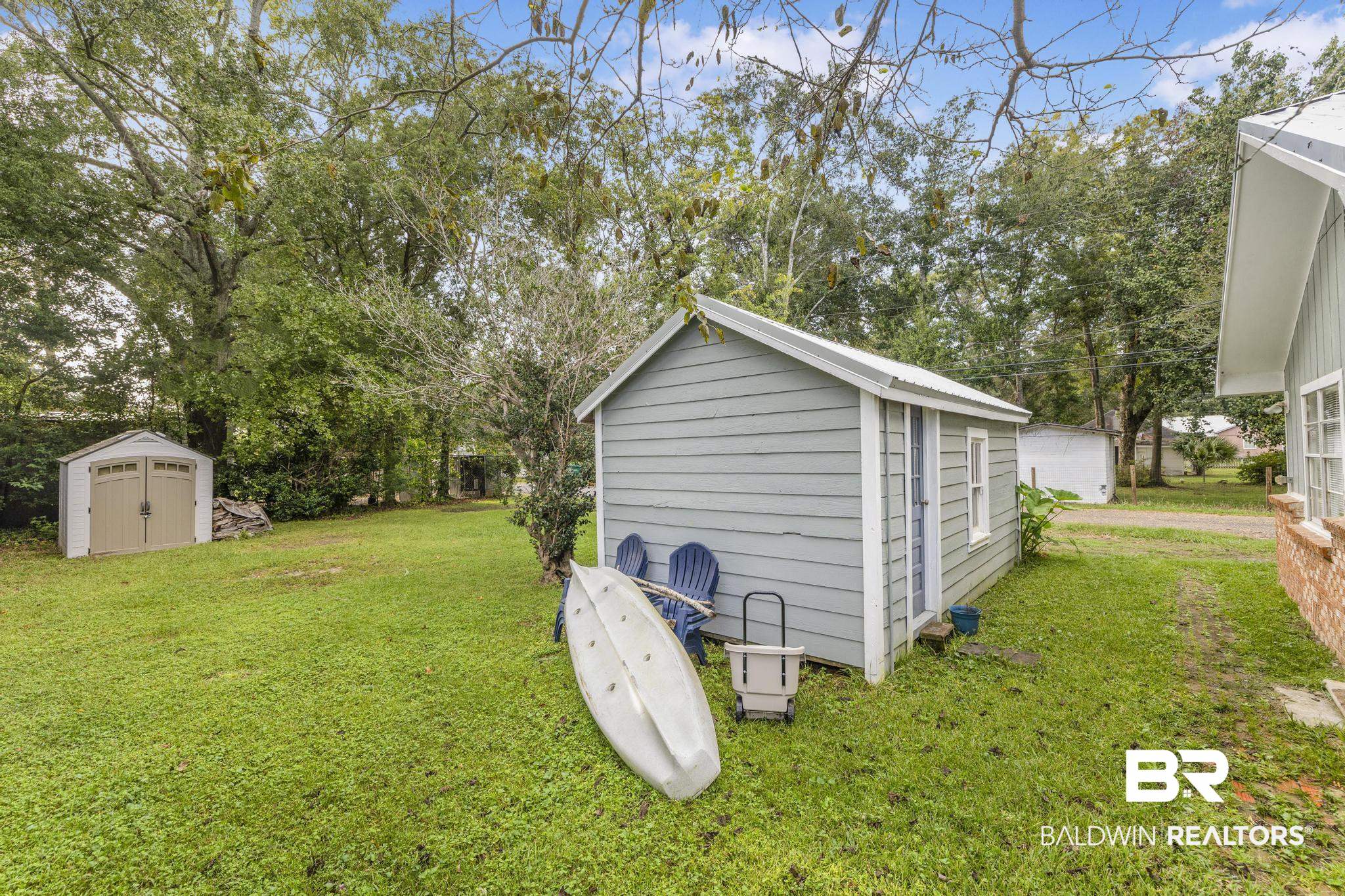 405 North Pine Street Foley, AL 36535 - Photo 10 of 33 View of green lawn with a storage unit and view of scattered trees