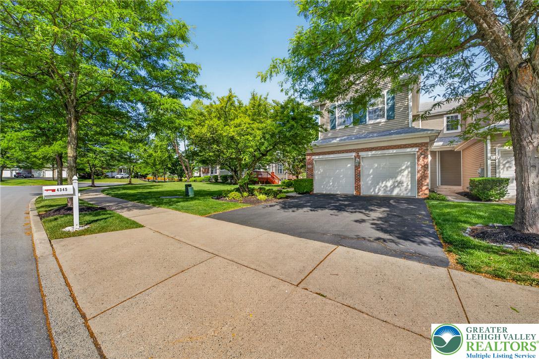 4345 Creek Road Allentown, PA 18104 - Photo 3 of 33 A classic two-story residence boasts an attached two-car garage, welcoming driveway, sidewalks, and vibrant green lawn.