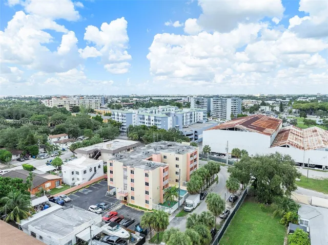 a aerial view of a brick building with many windows and yard
