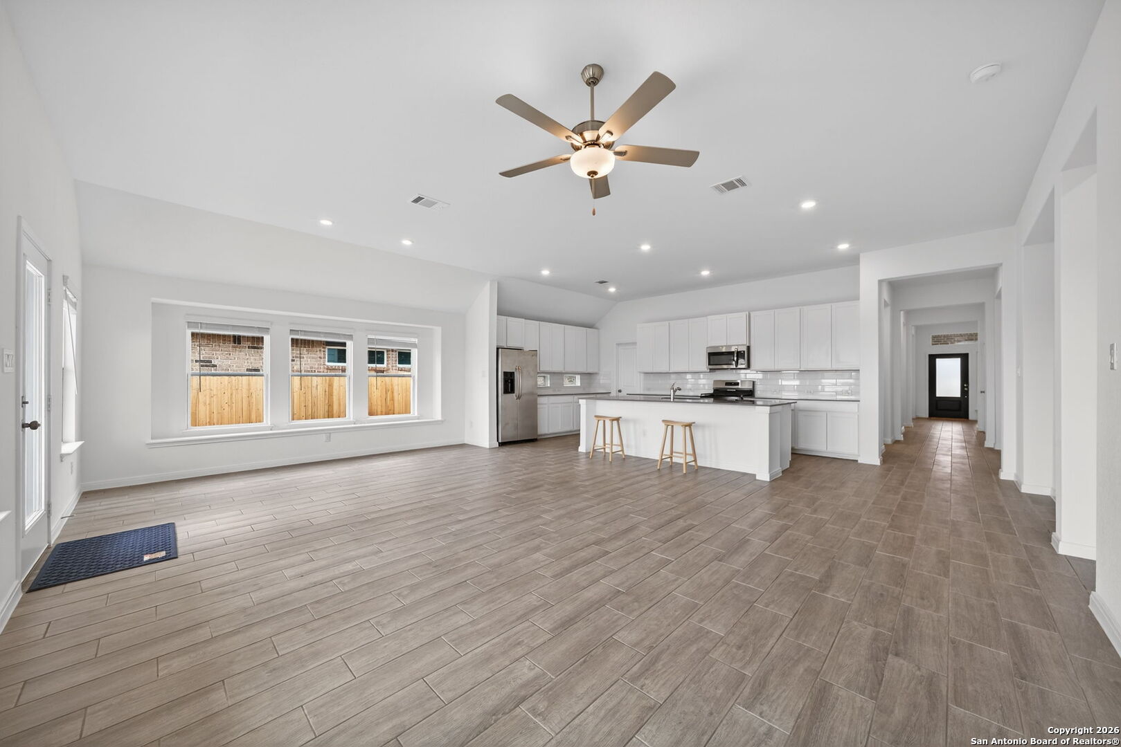 5755 Musquiz Ridge Seguin, TX 78155 - Photo 8 of 31 a view of an empty room with wooden floor and a kitchen