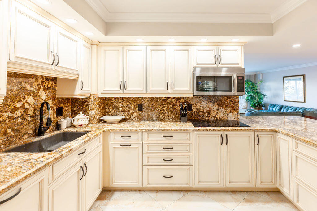 875 East Camino Real Boca Raton, FL 33432 - Photo 6 of 31 a kitchen with granite countertop a sink and a stove