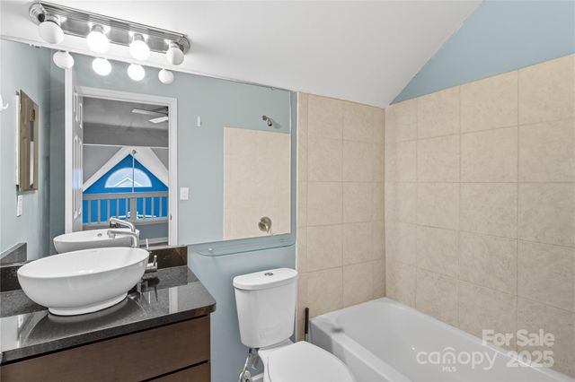 a bathroom with a granite countertop sink mirror vanity and toilet