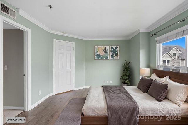 a bedroom with a bed and a painting on the wall